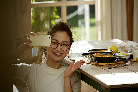 在拍摄美食的时髦美女图片