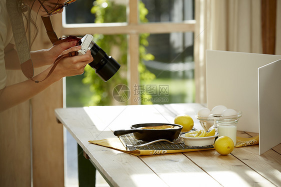 在拍摄美食的时髦美女图片