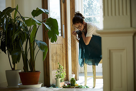 在客厅拍摄美食的时髦美女图片