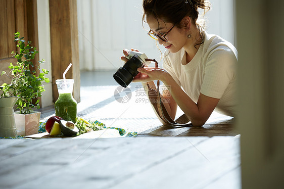 在客厅拍摄美食的时髦美女图片