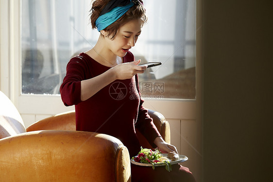 女人手机拍照分享自制健康早餐图片