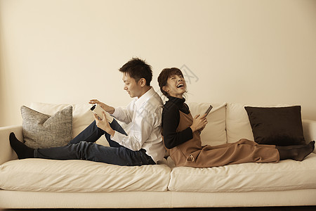 在公寓沙发上放松玩闹的夫妇图片