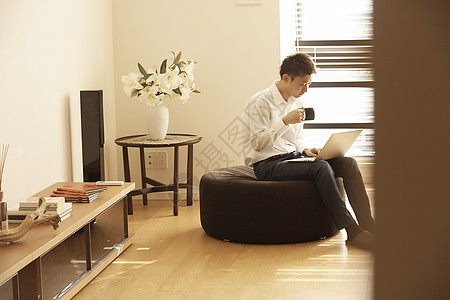 咖啡椅男人坐在沙发上喝咖啡用电脑工作背景