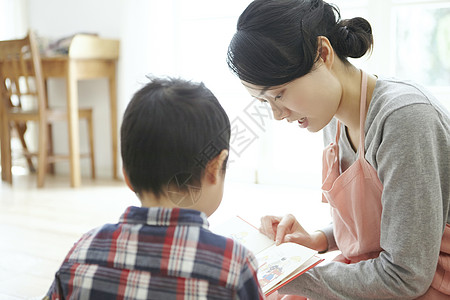 保育员在和孩子一起看书图片