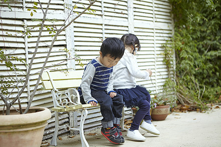 坐在花园长椅上的两个孩子图片