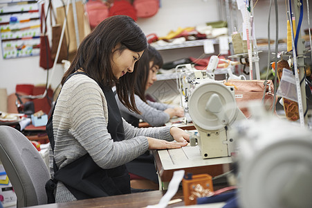 遵义道真县在制作手提包的女缝纫工背景