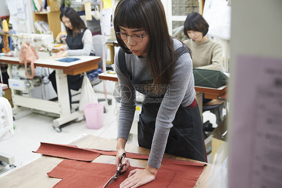 正在剪裁布料的女工人图片