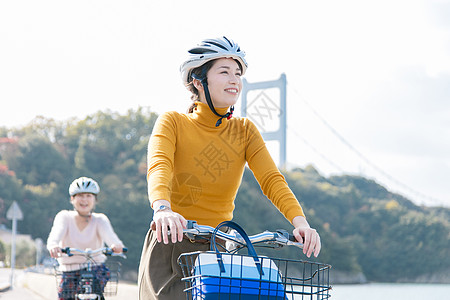 双人自行车戴着头盔骑自行车的两名女性背景