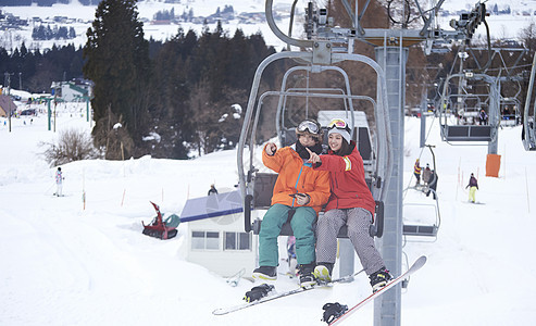 参加俱乐部滑雪活动的情侣在缆车上聊天图片