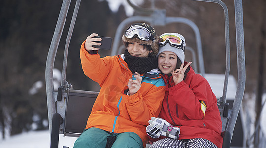 参加俱乐部滑雪活动的情侣在缆车上自拍图片
