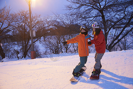 参加俱乐部滑雪活动的情侣在雪地练习图片