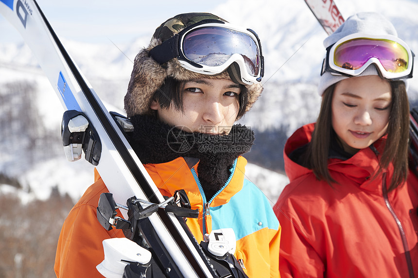 拿着滑雪装备的青年男女图片