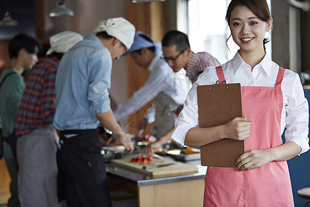 在学习烹饪的烹饪班成员在看镜头图片