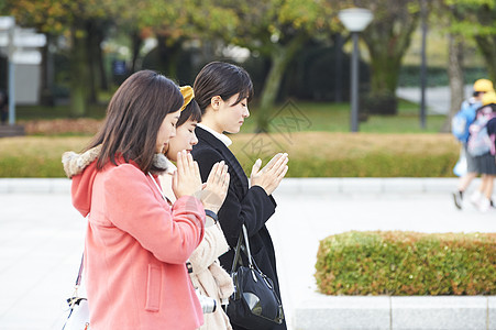 在广岛和平纪念公园祈祷的女人背景图片