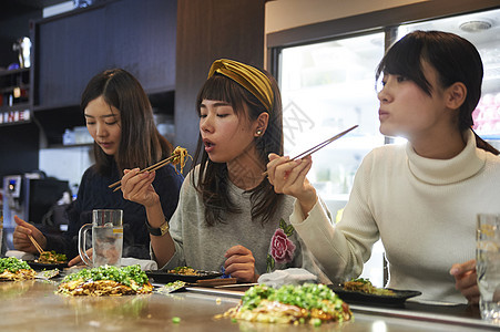 三个女生一起开心的吃大阪烧图片