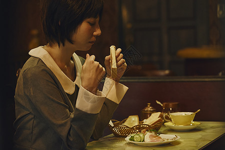 咖啡厅里孤独的吃吐司的女生图片