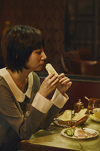 在咖啡馆吃吐司喝咖啡的女顾客背景图片