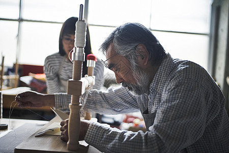 手工艺人在指导学生装订书籍图片