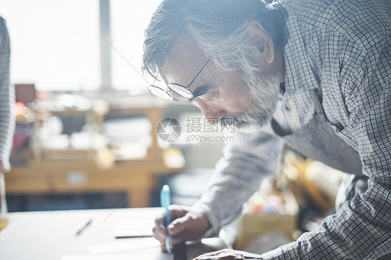 手工艺人在指导学生装订书籍图片