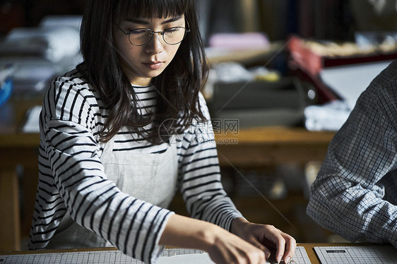 手工艺人在指导学生装订书籍图片