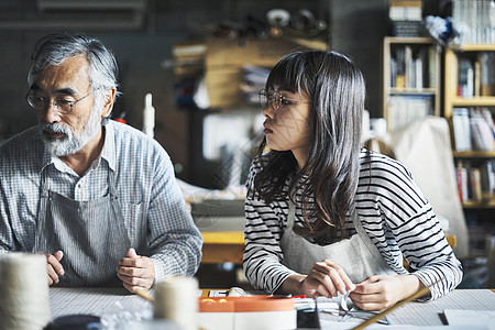 正在装订书本的师徒二人图片