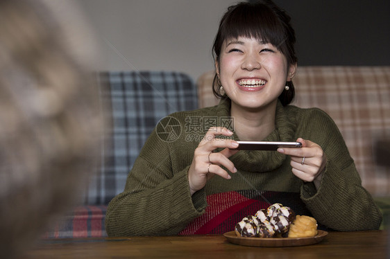 拍摄食物照片的年轻女人图片