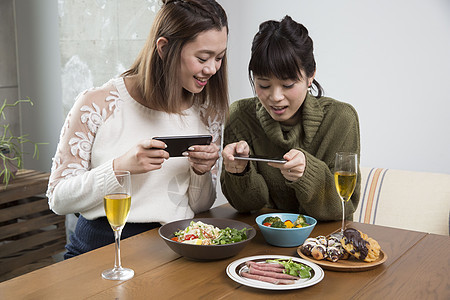 拿着手机给食物拍照的女人图片