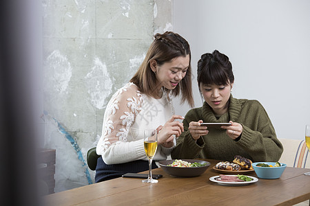 拍摄食物照片的年轻女性图片