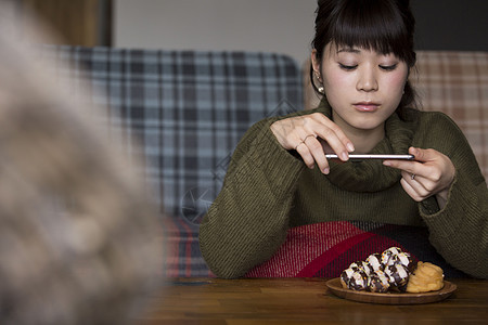 拍着食物照片的年轻女性图片