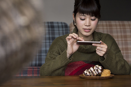 愉快的拍着食物照片的年轻女性图片