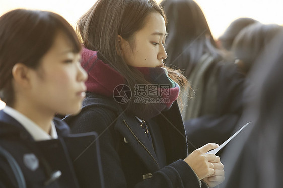 手拿成绩单表情紧张的女学生图片