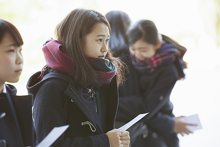 手拿成绩单表情紧张的女学生图片