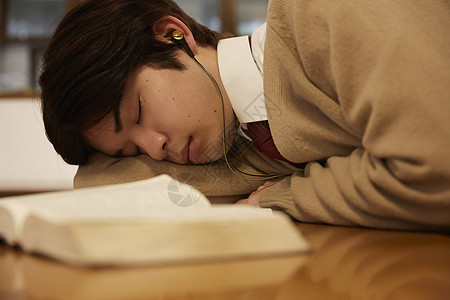 带着耳机看书睡着的男孩图片