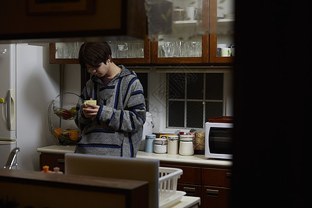 备考的男孩子在厨房内喝饮料图片