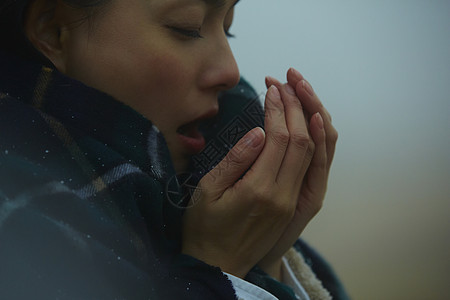 女孩景色对着手哈气取暖的女人背景