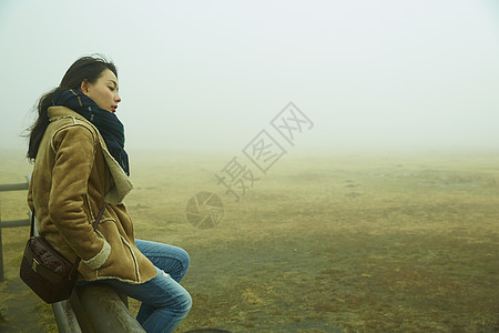 坐在栏杆上休息的女人图片