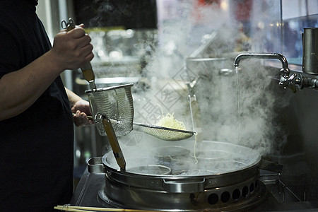 厨师把煮好的拉面捞上来高清图片