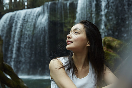 站在小溪边享受瀑布的女人抬头看图片