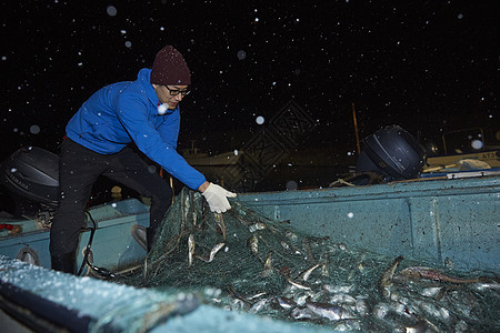 夜晚拉着渔网收获的渔民图片