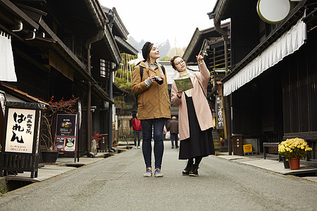 带着相机外国妇女和拿着地图的日本妇女在老街道采风岐阜县图片