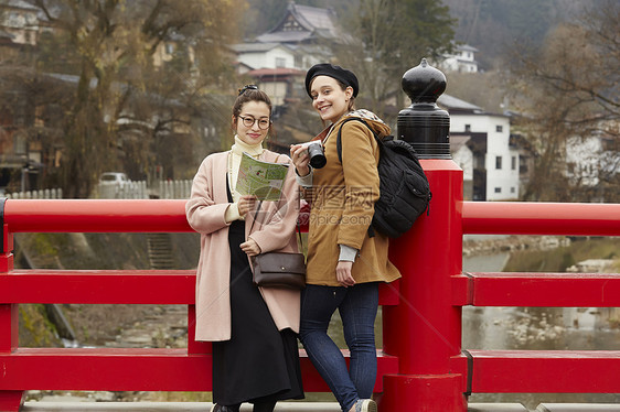 带着相机外国妇女和拿着地图的日本妇女在老街道采风岐阜县图片