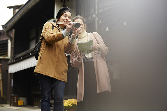 带着相机外国妇女和拿着地图的日本妇女在老街道采风岐阜县图片