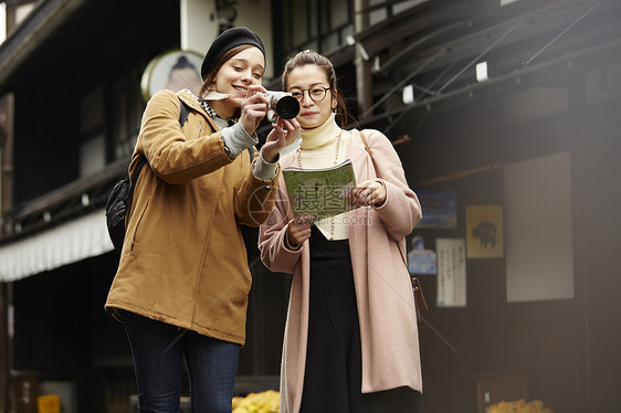 带着相机外国妇女和拿着地图的日本妇女在老街道采风岐阜县图片