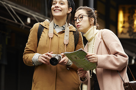 游览地图带着相机外国妇女和拿着地图的日本妇女在老街道采风岐阜县背景