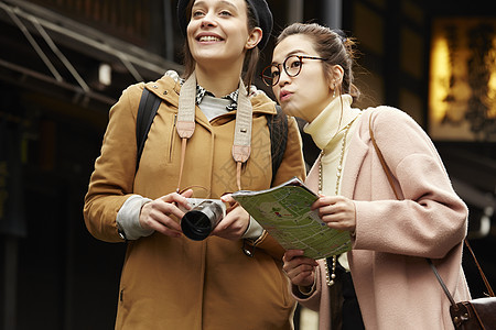 带着相机外国妇女和拿着地图的日本妇女在老街道采风岐阜县图片
