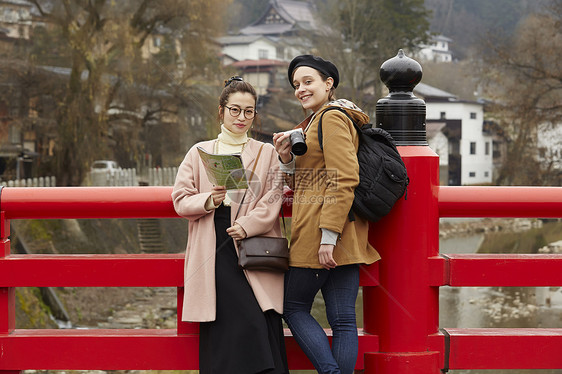 带着相机外国妇女和拿着地图的日本妇女在老街道采风岐阜县图片