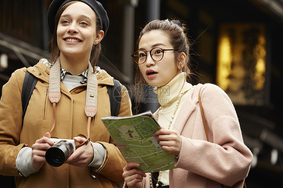 带着相机外国妇女和拿着地图的日本妇女在老街道采风岐阜县图片