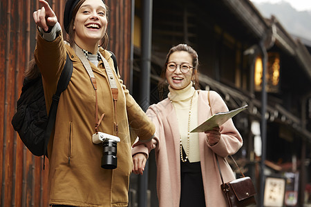 带着相机外国妇女和拿着地图的日本妇女在老街道采风岐阜县图片