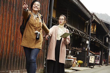 带着相机外国妇女和拿着地图的日本妇女在老街道采风岐阜县图片