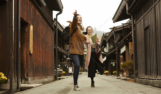 带着相机外国妇女和拿着地图的日本妇女在老街道采风岐阜县图片